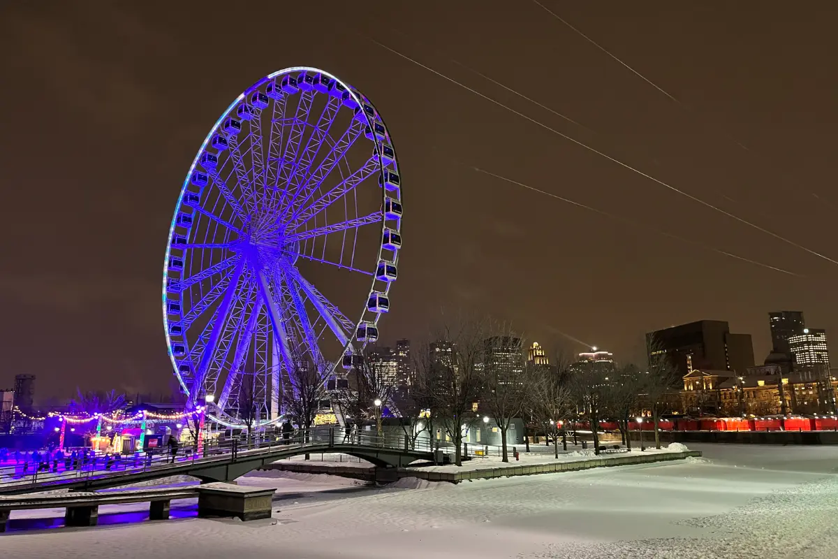 Old Port Montreal iceskating rink and ferris wheel lit up at night in Winter