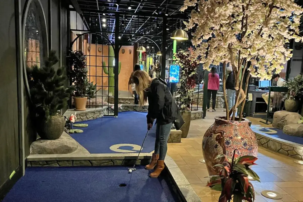 Woman about to hit her ball at the Puttery in Charlotte NC mini golf