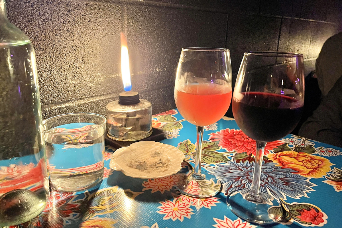 Wine glasses and a candle at a table with a floral pattern on it