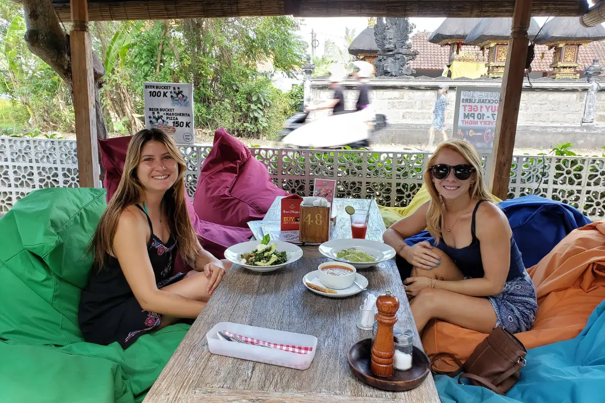 Two new friends who met during solo travel, eating lunch in Bali