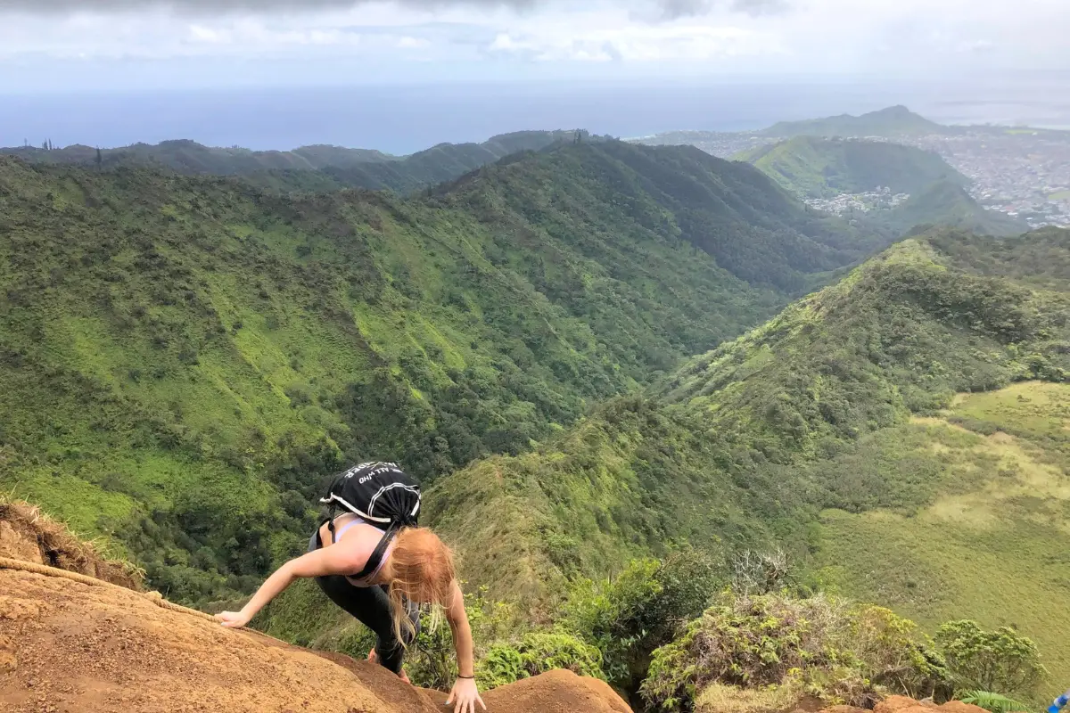 Backpacker doing haiku stairs hike in Oahu Honululu, to visually display one of the best benefits of solo travel which is expanding your comfort zone 