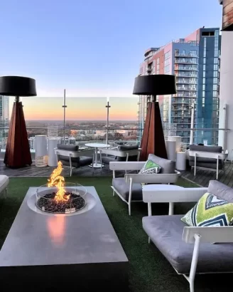 The rooftop at Kimpton Tyron Park hotel, Merchant and Trade, with a fire pit and the sun setting in the background, with romantic ambiance