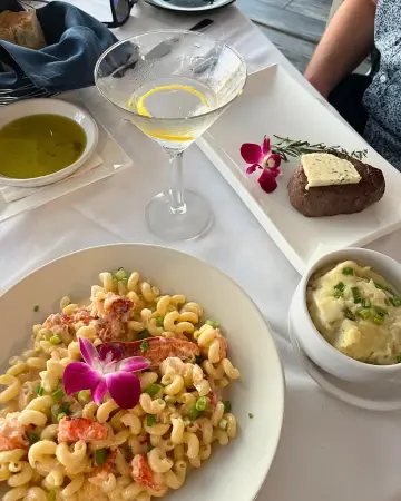 Pasta and steak dishes on the table at Spinners rooftop restaurant