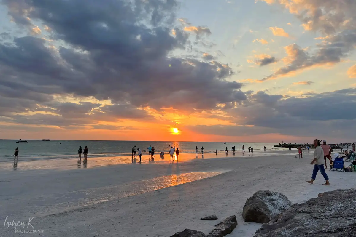 Sunset over St Pete Beach near Jimmy B's beach bar, with people on the beach enjoying watching 