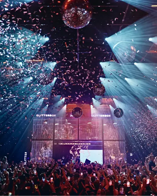 People dancing under a disco ball and confetti at the Glitter Box Ibiza club night