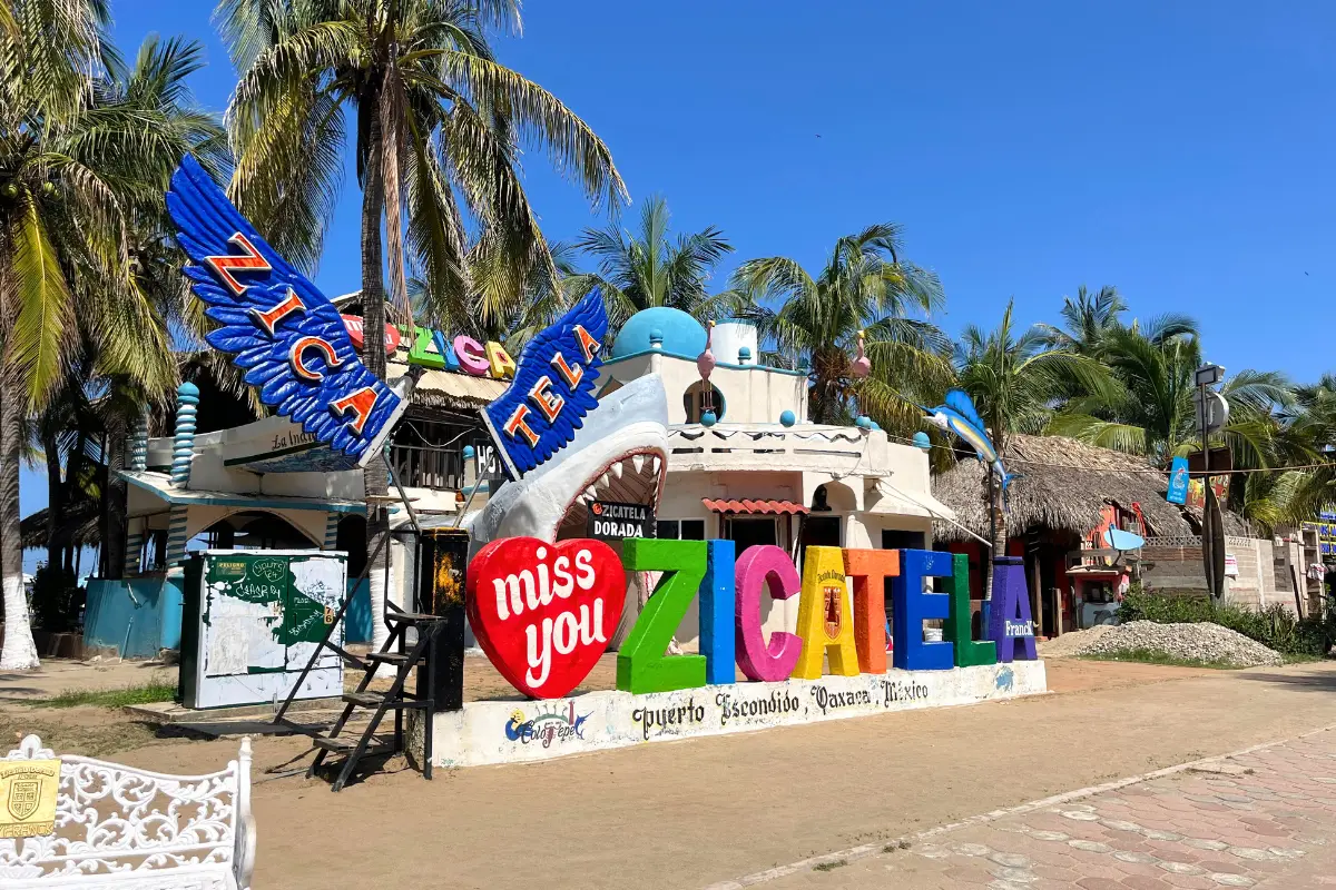 The Zicatela sign on the beach in Puerto Escondido, with palm trees behind and truly looking like a tropical paradise