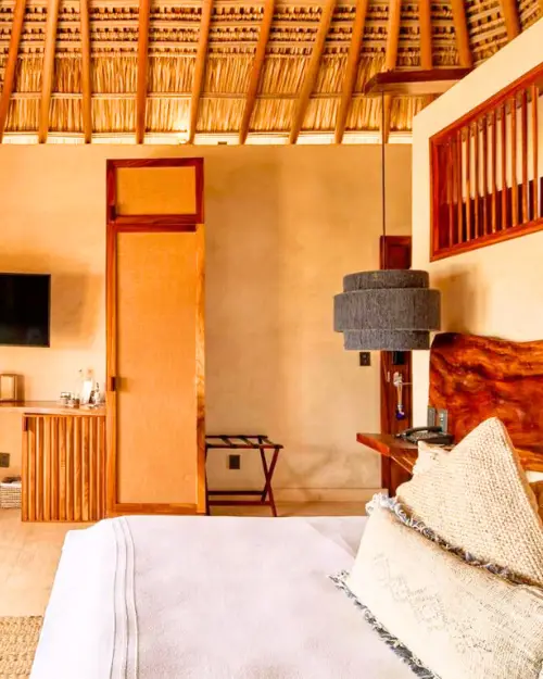 Hotel room with a thatched roof with a very tropical boho feel