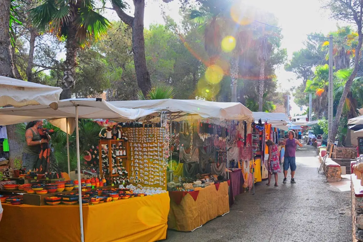 The Punta Arabi hippy market Ibiza, which is the oldest hippy market on the island, with a few people shopping at booths as the sun rises