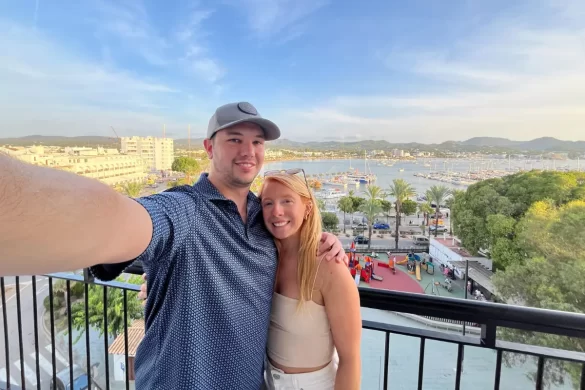 A selfie of my husband and I with the view of San Antonio bay in the background, which we took on our balcony at the Red Hotel showing that it's an excellent deal