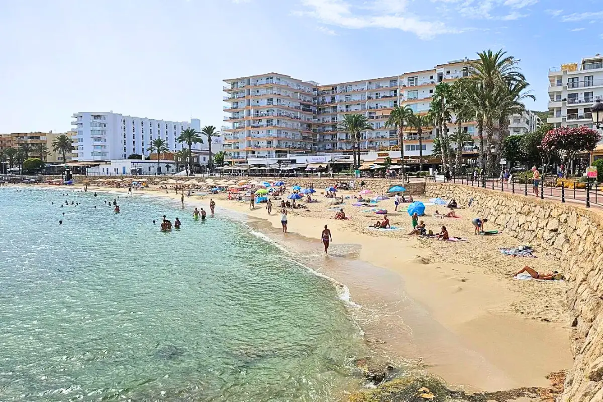 Santa Eulalia beach and strip with hotels and restaurants, on a sunny day with people enjoying the beach