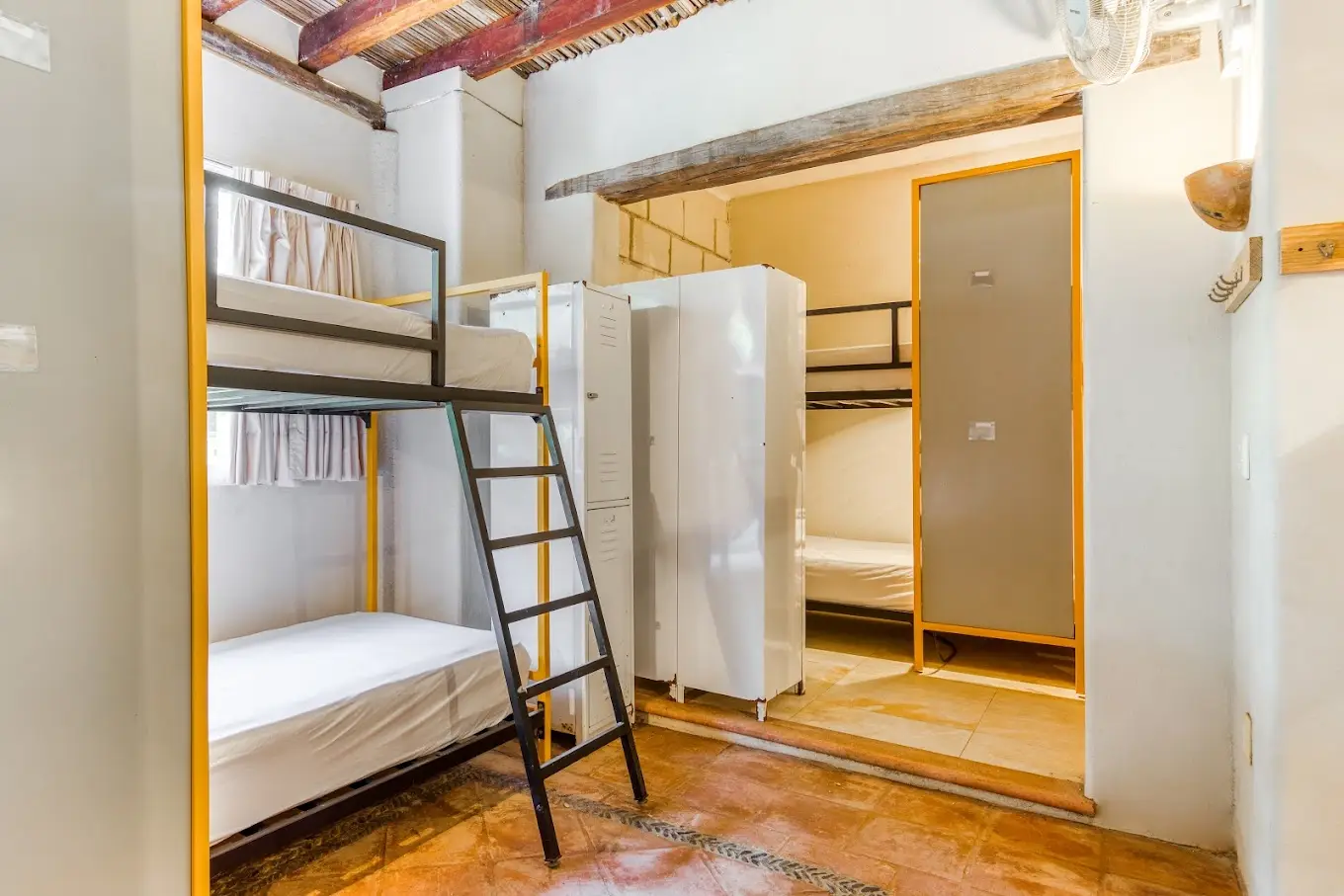 An industrial style dorm room bunk bed and locker area with brightly colored design