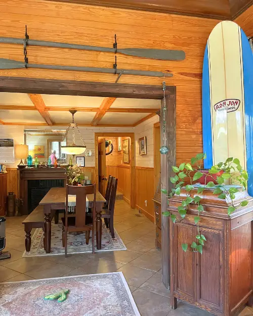 Lobby with a Ron Jon surf board, wooden panel walls and antique boho decor