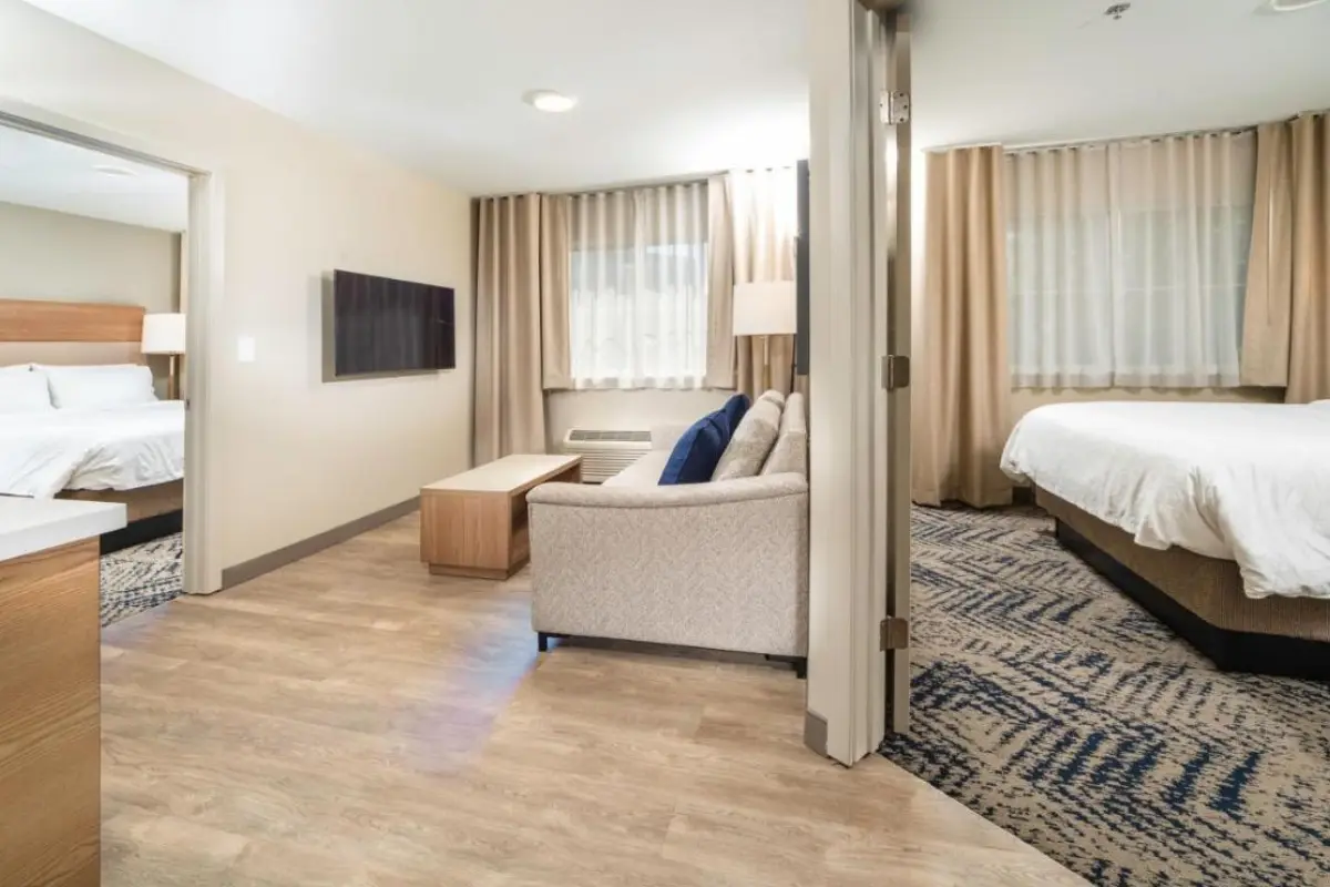 Two bedroom suite at the Candlewood Suites with a small sitting area and neutral decor