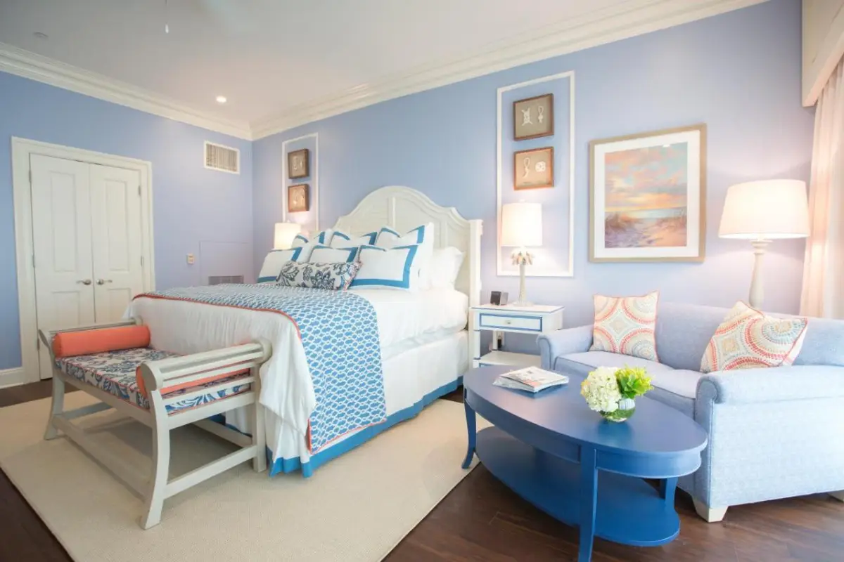 Cute, preppy interior of a room at the Harborside section of the Charleston Harbor Resort.& Marina with a small sitting area and a blue and orange theme