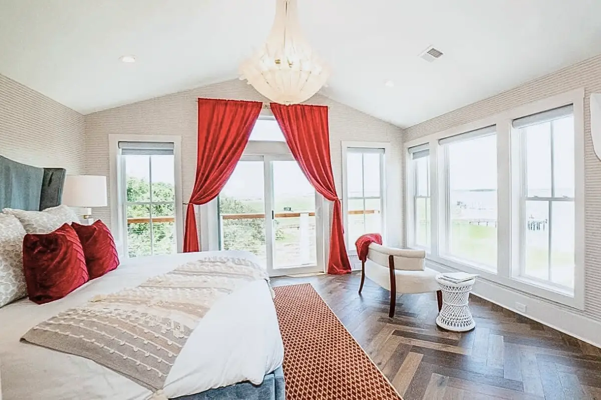 Luxurious looking suite with red curtains overlooking a marsh, at the Regatta in Folly Beach