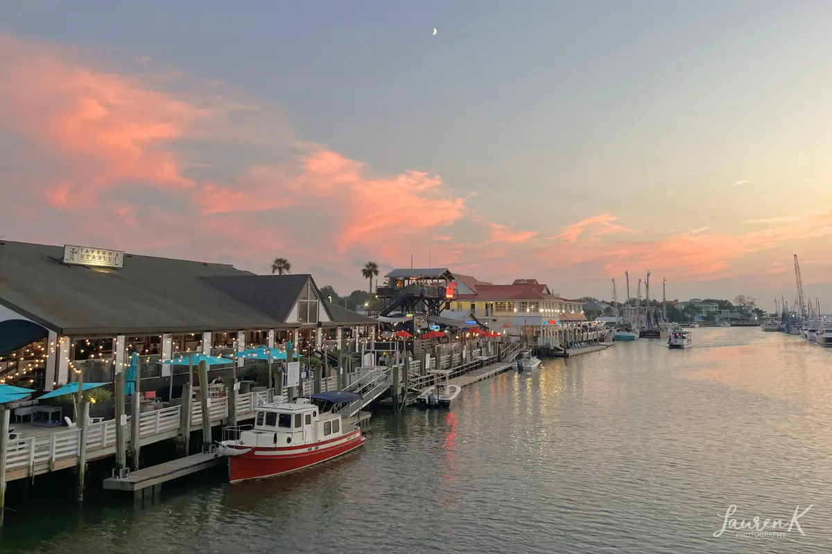 Photograph I took during sunset at Shem Creek under a crescent moon with restaurants and bars along the water