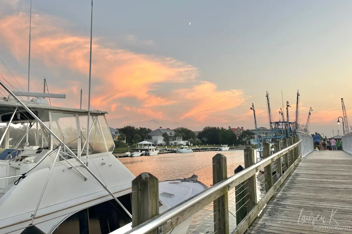 Sunset at the pier at Shem Creek with a boat in the foreground and moon in the sky, which I took during my last trip during a photography shoot