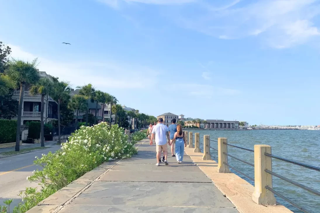 People walking down a waterfront path in downtown Charleston 