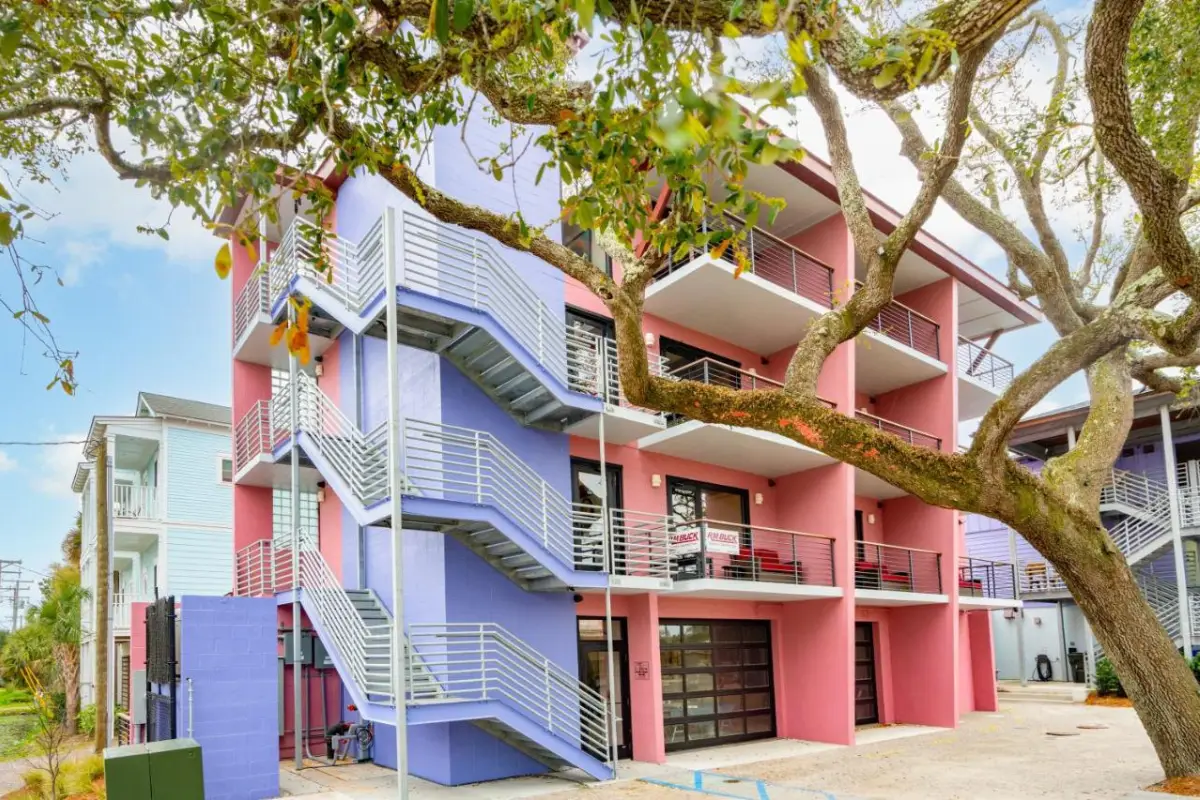 The cool purple and pink exterior of the trendy Vera Hotel in Folly Beach, which is one of the best choices for where to stay in Charleston SC on a budget near the beach