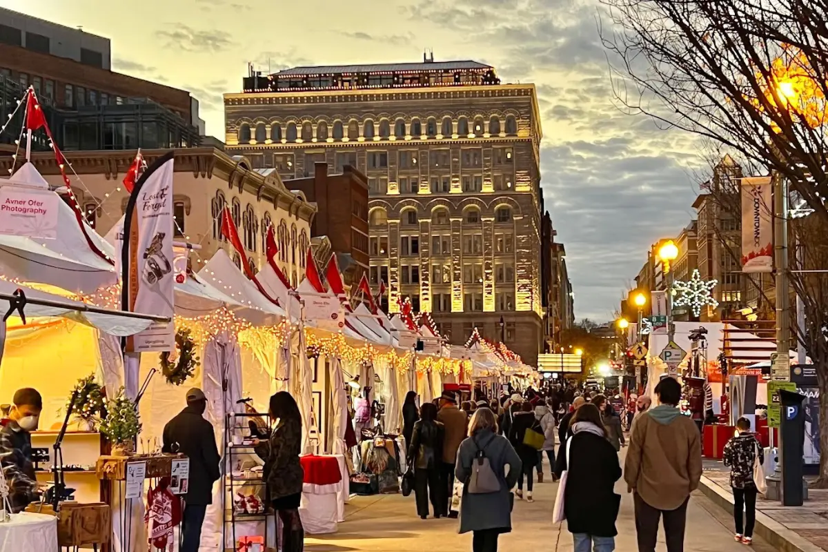 People walking through the Downtown DC Holiday market at Penn Quarter during sunset time