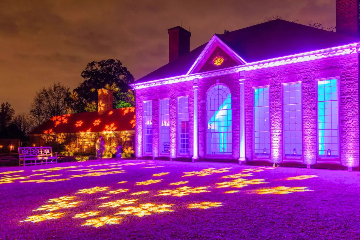 Mount Vernon glowing purple with snowflakes projected onto the grounds