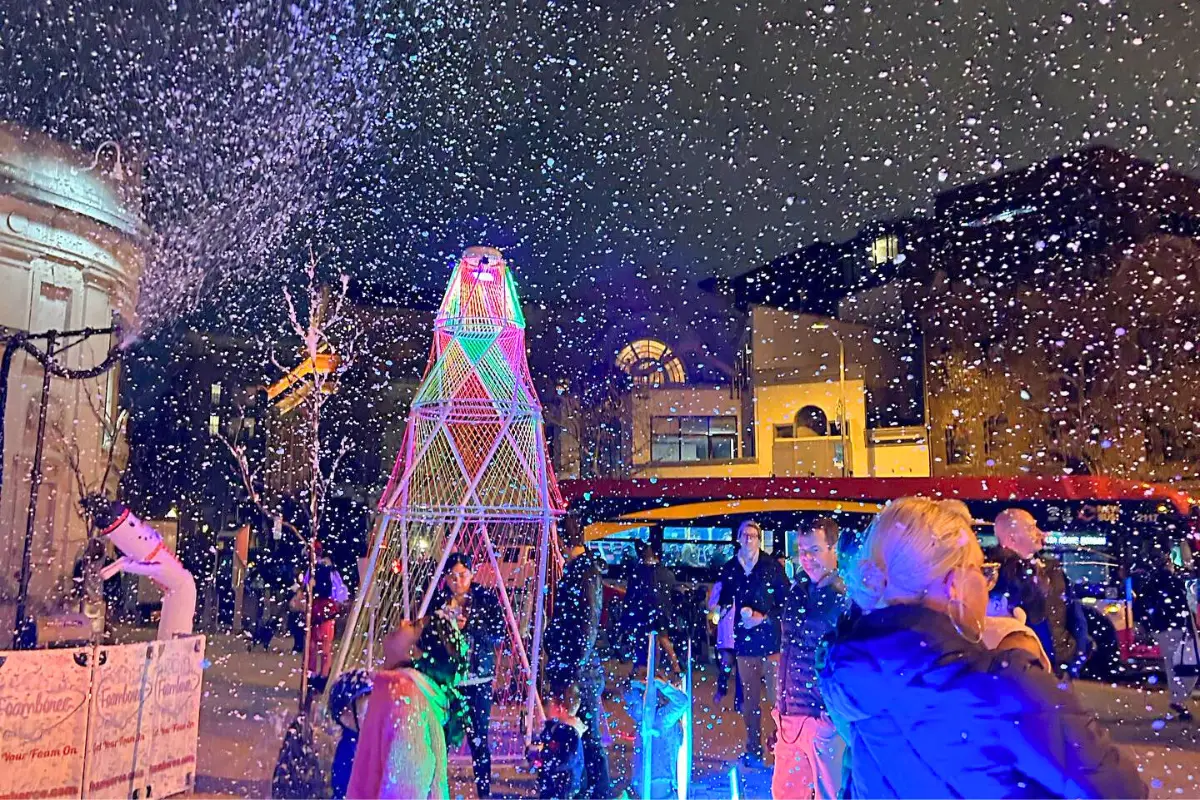 Fake snow falling at Adams Morgan's  Snow Thursdays event with holiday lights and people hanging out