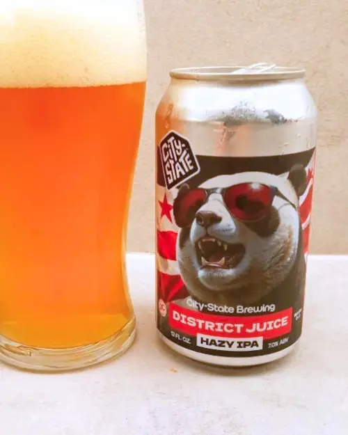 The District Juice hazy IPA can with it poured into a pint glass next to it, to show off one of City-State Brewing's best beers