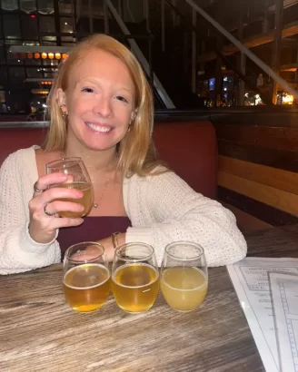 A photo of Lauren of Inspired Backpacker with a beer flight at Bluejacket