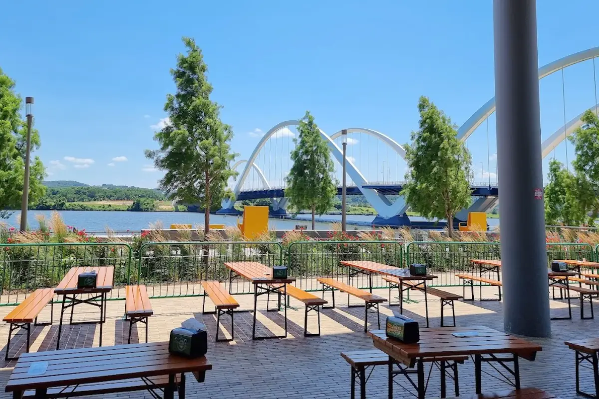 Outdoor space at Solace Brewing looking over the water and a cool, futuristic looking bridge in Navy Yard on a sunny day