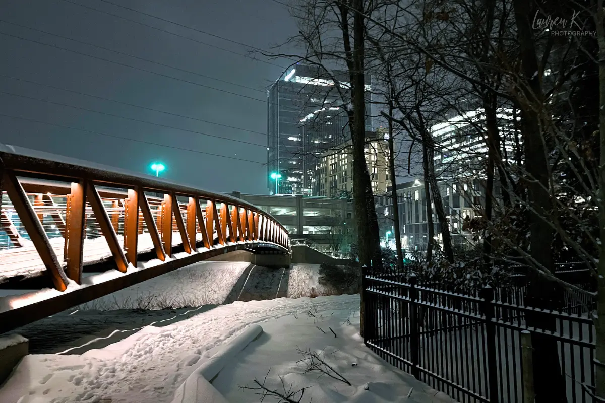 Bridge and buildings lit up in Reston behind the W&OD trail