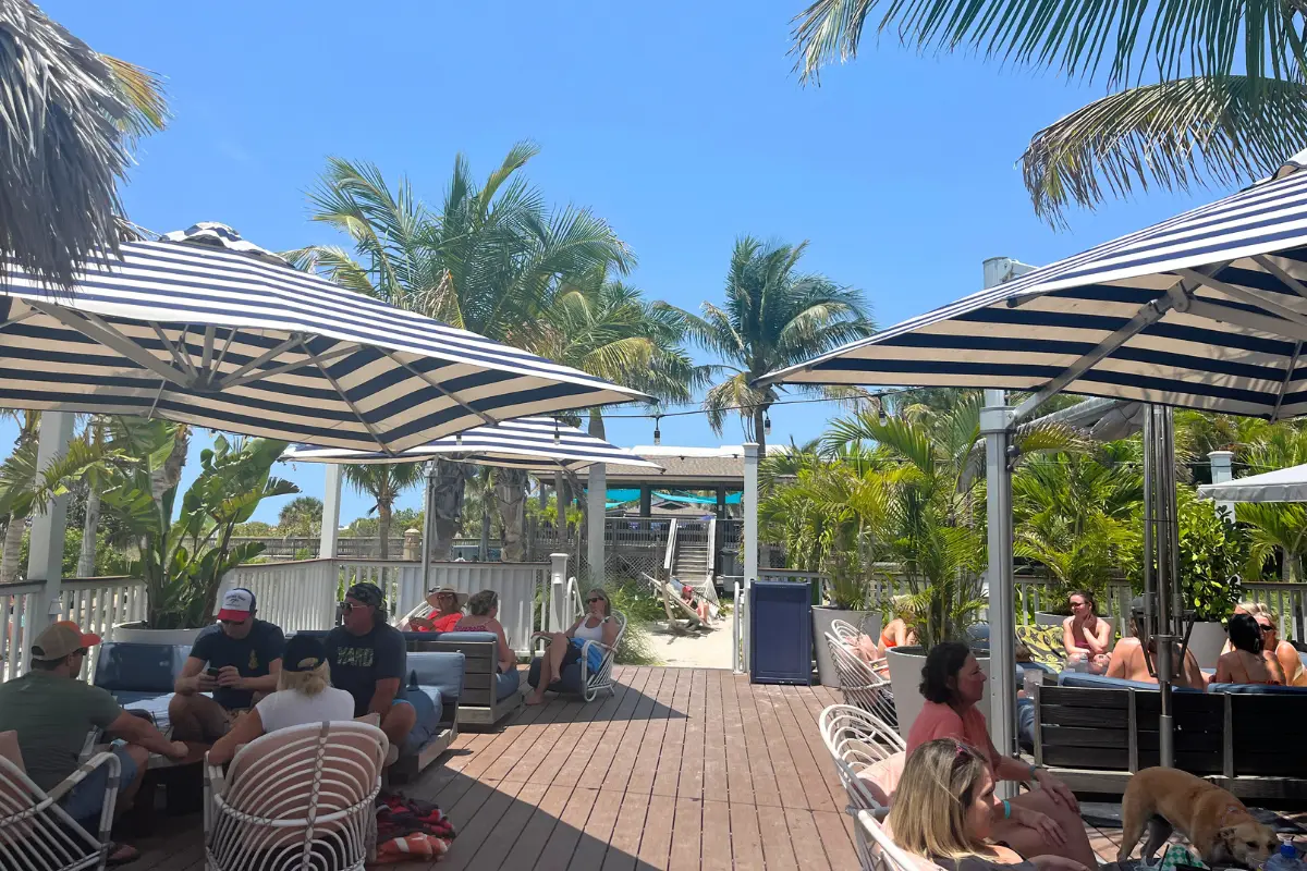Coconut Charlie's beach bar at St Pete Beach, with large umbrellas over lounge areas and palm trees